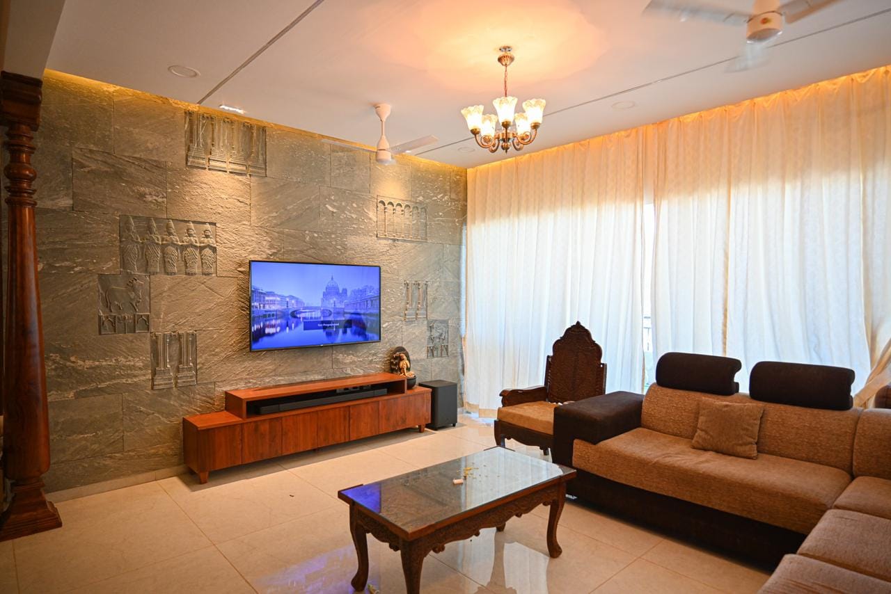 Formal living and lounge sitting area with sectional sofa, coffee table, and classical carved stone feature wall