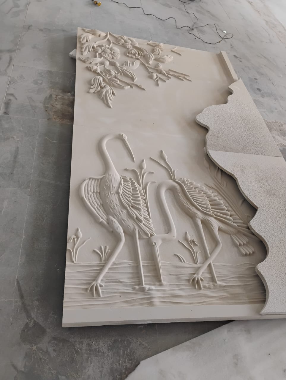 Sandstone entrance foyer wall relief featuring hand-carved egret cranes among water lotus blooms