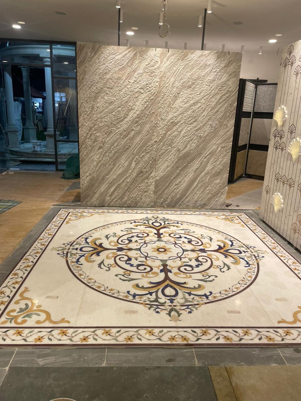 Grand white marble floor inlay carpet medallion with intricate floral borders installed on polished marble flooring