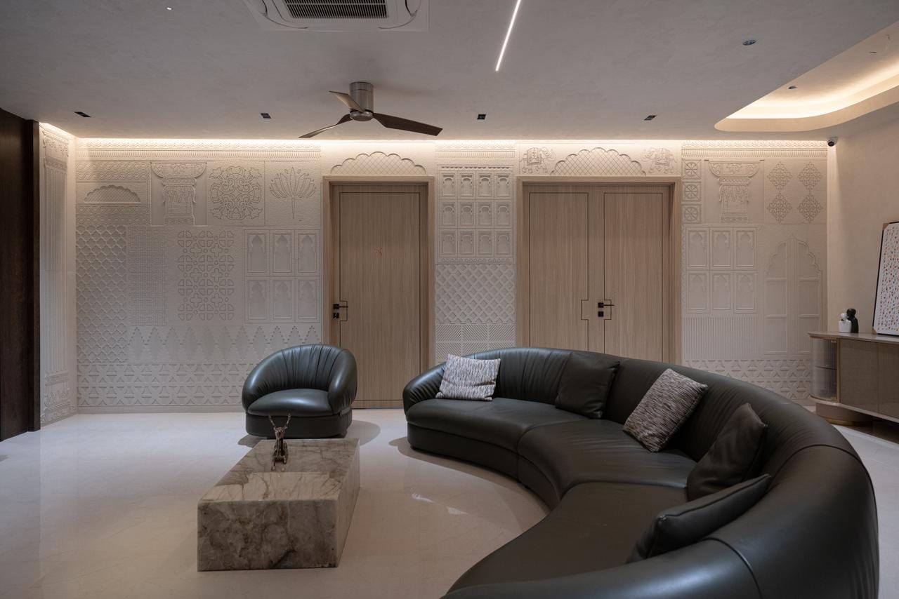Luxury formal living room featuring Rajasthani carved jali stone wall panels behind curved seating